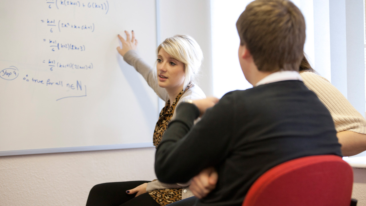 Maths teaching publicity shots of 2nd year students engaging with 1st year students in PALS (Student led support sessions)