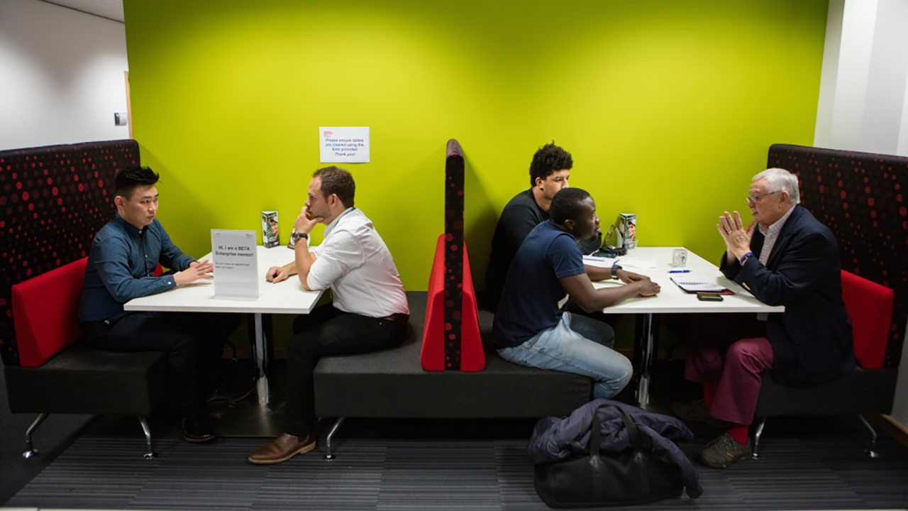Students talking to mentors in booths