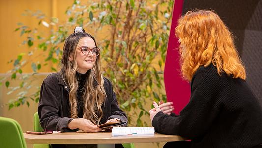 Student and advisor sitting at a table talking