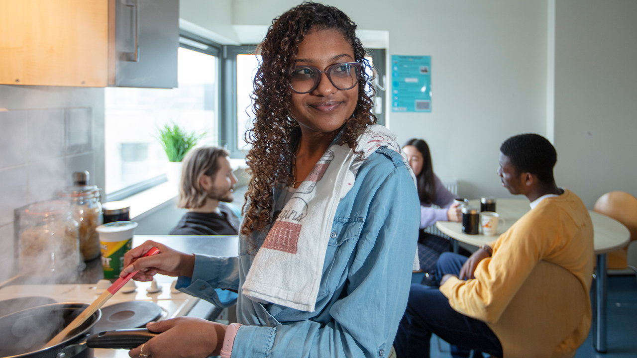 Female student cooking in Radnor Halls accommodation shared kitchen (1280x720)