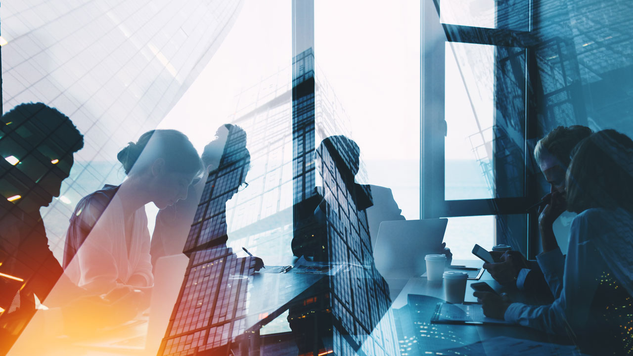 Business concept image. Workers in a meeting with skyscrapers overlaid.