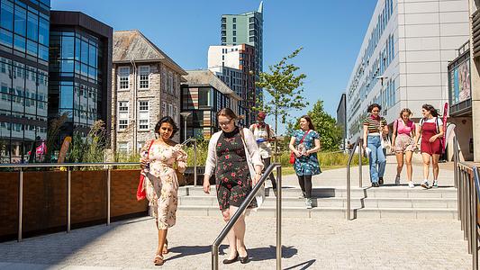 Students walking across campus on a sunny day