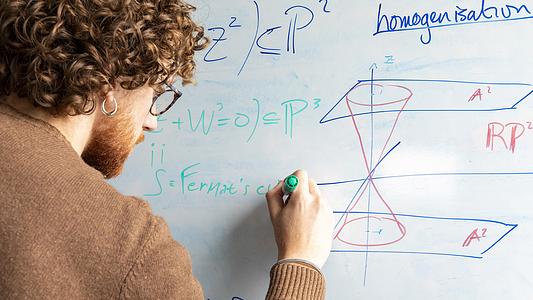 Mathematical Science student writing on whiteboard